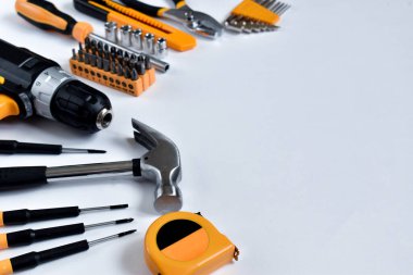 Beyaz arka planda ev onarımı ve bakım için el aletleri olan çeşitli inşaat araçları.