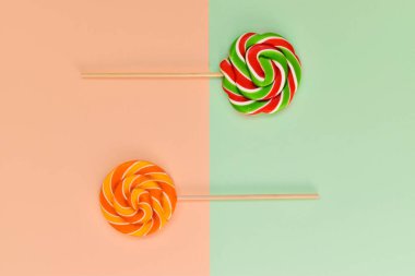 Geometrik arka planda tahta bir çubuk üzerinde bir çift şeker. Kartpostal Doğum günü tatlı karamel. Burası boş bir yer. Üst Görünüm Düz Düzen