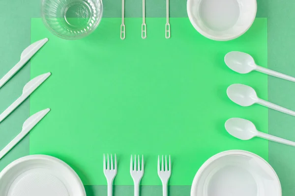 Quadro de utensílios de plástico sobre um fundo verde . — Fotografia de Stock