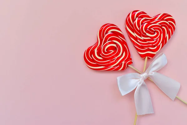 Lollipops on a stick in the shape of a heart with a bow close-up