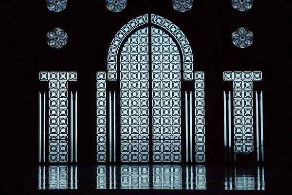 Glasdeur in de Hassan Ii moskee in Casablanca Marokko. Gebouwd over de zee, het laat het blauwe licht door het sierglas. — Stockfoto