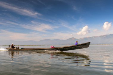 Bambu teknesindeki Birmanlar, Myanmar 'ın Nyaungshwe şehrinde bulunan bir tatlı su gölü olan Inle Sap üzerinde yelken açarlar..