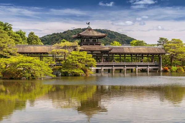 Heijan jingu santuário jardim, Kyoto, Japão. Ponte de madeira tradicional que reflete em um lago, rodeado por jardim de verão verde . — Fotografia de Stock