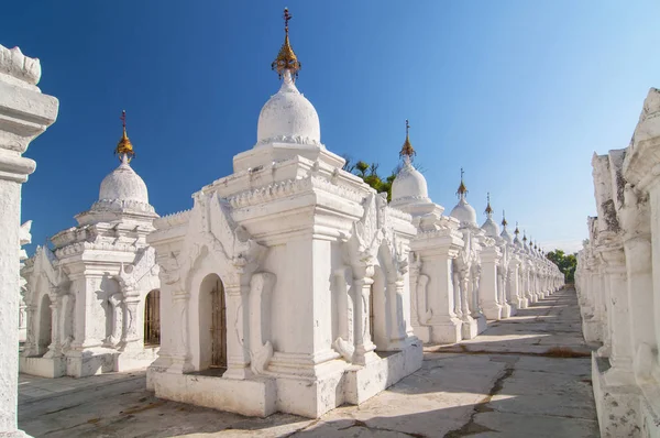 Kuthodaw Pagoda contains the worlds biggest book. There are 729 white stupas with caves with a marble slab inside page with buddhist inscription. Mandalay, Myanmar. — Stock Photo, Image