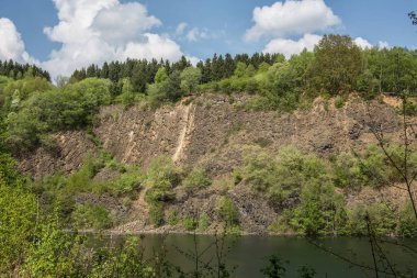 Göldeki bazalt kayasından yapılmış dağ yamacı.