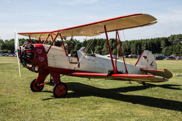 red biplane airplane on meadow