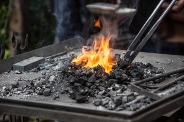Yanan alevler ve dövülmesi gereken atölyelerle ateş yak