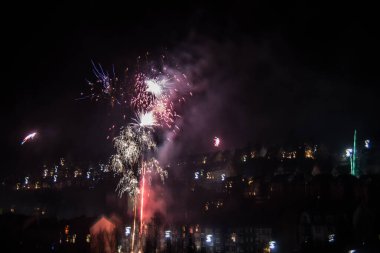 Gökyüzünde ışık izleri olan yeni yıl havai fişekleri.