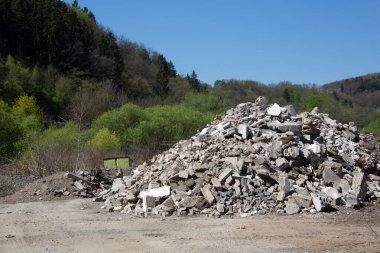 Tepedeki ormanın önündeki inşaat atığı.