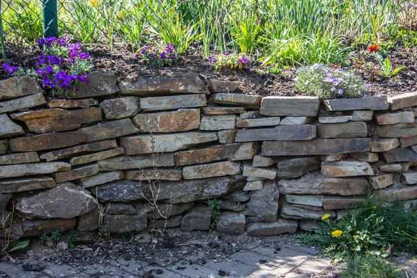 花园里用天然石头筑成的干石墙 — 图库照片