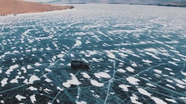 Araba buz tutmuş Baykal Gölü 'nde kayıyor. Pürüzsüz buz ve hava manzarası var.. — Stok video
