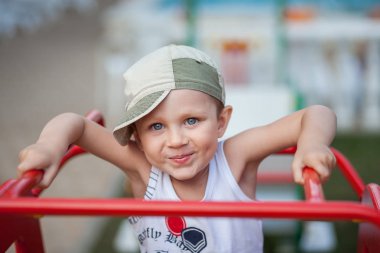 little boy in a cap plays in the playground