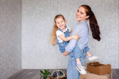 Neşeli anne, küçük kız yeni bir dairede duruyor. Bir çocuk ablasıyla, dadısıyla ya da sevgi dolu bir anneyle eğlenir. Aktif eğlence ve yaşam tarzı kavramı.. 