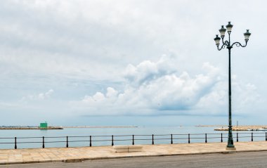 Yan sokakta lamba ile bulutlu havalarda deniz manzarası.