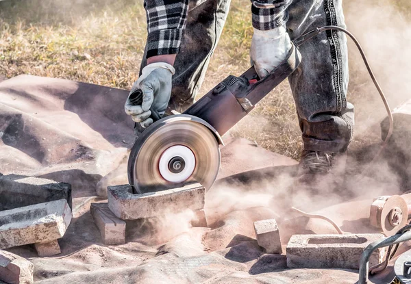 Worker cutting bricks with circular saw