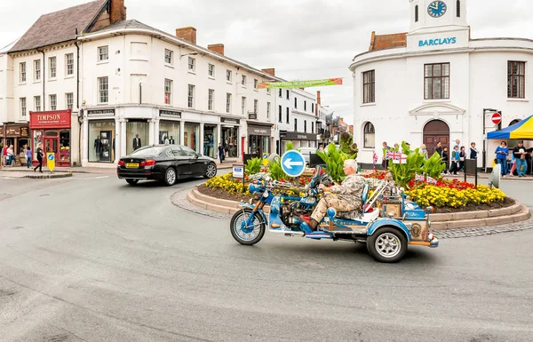 A man drives his Harley Davidson motorbike through the centre of Stratford Upon Avon. — Stock Photo, Image