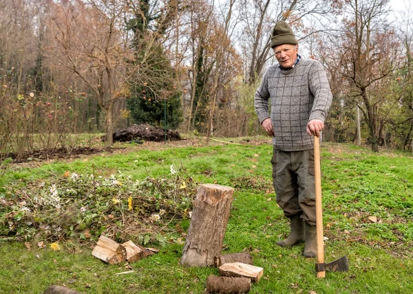 Hombre mayor con hacha en el jardín de otoño . —  Fotos de Stock