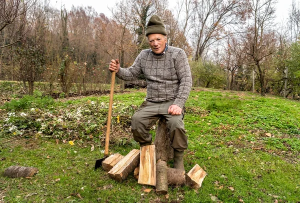 Hombre mayor con hacha en el jardín de otoño . —  Fotos de Stock