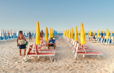 San Vito Lo Capo, Trapani, İtalya - 3 Ekim 2016: İnsanlar arasında ünlü San Vito Lo Capo plaj kapalı şemsiye ve şezlong günün sonunda.