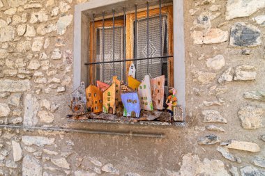 Eski bir taş evde renkli ahşap süslemeleri olan eski bir pencere..