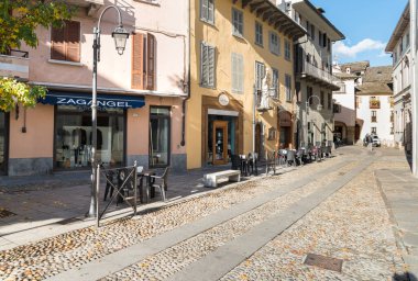 Domodossola, Piedmont, İtalya - 11 Kasım 2016: Domodossola, İtalya 'nın tarihi merkezinde tipik açık hava barları ve dükkanları olan yaya sokağı