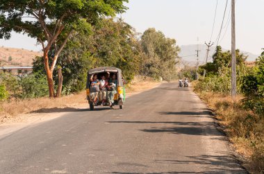 Puttaparthi, Andhra Pradesh, Hindistan - 12 Ocak 2013: Hintli kadınlar Puttaparthi köyü yolu boyunca rickshaw taksisiyle seyahat ederler
