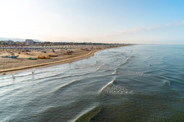 Versilia, Toskana, İtalya 'da sabahın erken saatlerinde Marina di Pietrasanta plajı beyaz kum, şemsiye ve sandalye manzarası
