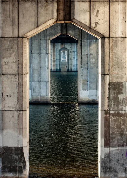 Big reinforced concrete pillars on water. Archways.