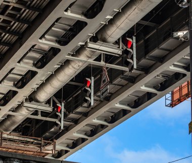 This image captures traffic signal devices positioned beneath a bridge, showcasing the engineering and signaling systems essential for ensuring road safety and regulation.