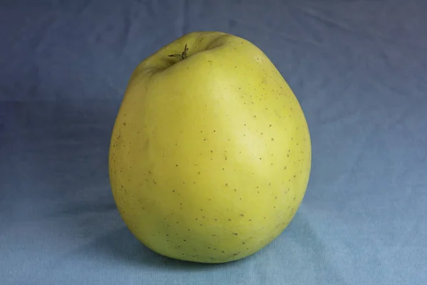 Manzana amarilla sobre azul —  Fotos de Stock