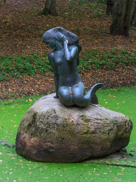 Deniz kızı bir kayaya bataklık havzasında eski bir park anıt