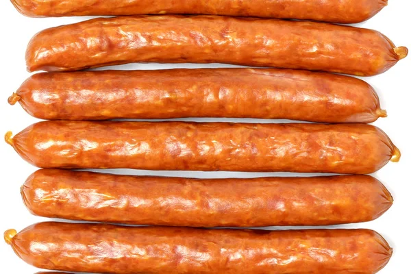 Background of dry sausages. Kabanos sausages folded in a row close-up on a white background. — Stock Photo, Image