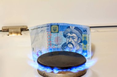 Gaz ocağı, arka planda bir yangın var. Beş hryvnias. Ukrayna 'da benzin fiyatları kavramı
