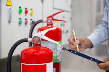 Mühendis yangın söndürücünün basınç göstergesini kontrol ediyor yangın, acil durum ve güvenlik kavramı için..
