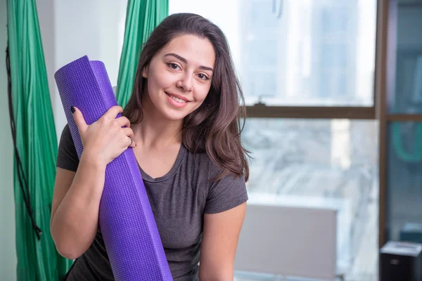 Portrait of young yoga woman yoga trainer indoor. Beautiful girl practice yoga in class. Yoga studio instructor. Blurred background