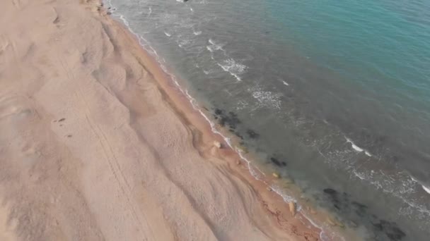 Vista superior de la playa, olas rompen en la playa tropical de arena amarilla. Las olas del mar en la playa de arena amarilla. Video sobre agua azul turquesa en la orilla de la arena . — Vídeos de Stock