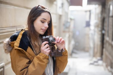 Bakü sokaklarını keşfeden genç turist kızın fotoğrafı. Eski şehri ziyaret eden ve şehrin fotoğraflarını çeken genç bir kızın karamsar fotoğrafları..