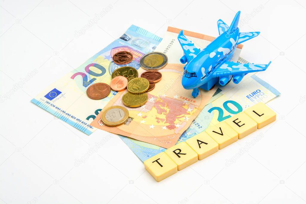 Travel expenses theme with euro banknotes and coins, plane and dice writing Holiday isolated on white background