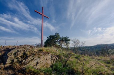 Taş tepede ahşap haç, mavi gökyüzü
