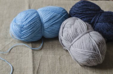 Doğal keten kumaşın üzerinde gri, mavi ve mavi renkte örgü iplikleri var.. 