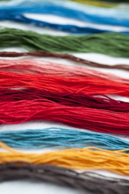 Parlak renkli nakış iplikçikleri. Koyu renk keçeli kumaş üzerine işlenmiş çok renkli iplikler. El yapımı nakış işleme arka planı