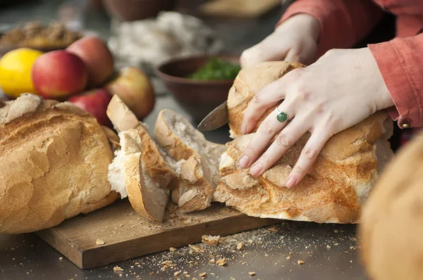 Резка хлеба на деревянной доске — стоковое фото