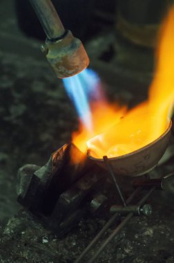 Profesyonel aletlerle mücevher yapımı. Makro atış. El yapımı kuyumcu, mücevher üretimi. Eriyen metal