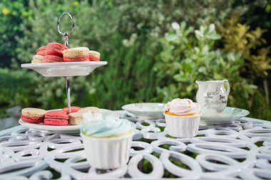 Bahçede pembe, beyaz renkli ve fincan kekli bir sürü makarna var. Tatlı tatlı. Rahatla konsept.