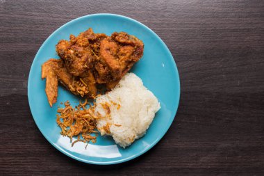 Beyaz tabakta kızarmış tavuk ve açık kahverengi ahşap arka planda Müslüman pirinci. Tayland 'da helal yiyecekler. Basit ve yerel yiyecekler.