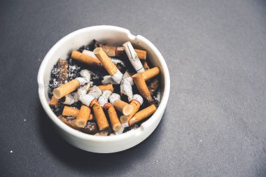 Masadaki kül tablasında bir sürü sigara izmariti var..