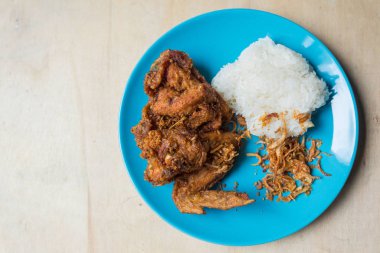 Kızarmış tavuk ve kızarmış soğan. Yapışkan pilav ve kahverengi ahşap açık mavi tabakta sos. Kızarmış tavuk Hat-yai Songkhla Tayland 'ın en ünlü yemeği. Kültür yemeği. Yağlı yemek..