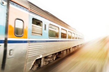 Günbatımında hareket halindeki klasik tren. Hareket bulanıklığı etkisi. Hızlı tren konsepti. Boşluğu kopyala.