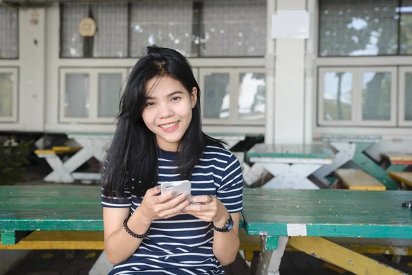アジアの女性は 携帯電話を再生するときに笑顔 — ストック写真