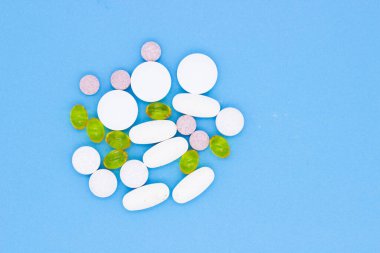 Vitaminler, haplar ve haplar. Mavi arka planda farklı vitaminler, haplar ve kapsüller..